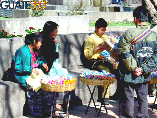 Niños y jóvenes vendiendo dulces en el parque de Xela