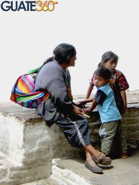 Viuda indígena con sus hijos a un costado de la iglesia de Chichicastenango