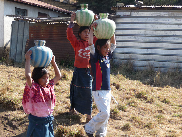 Patojitas transportando agua hacia sus casas