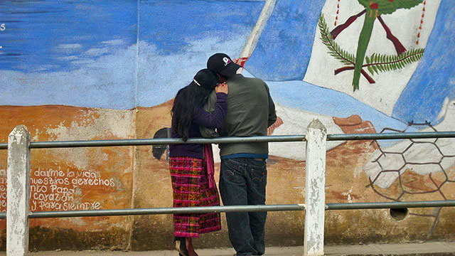En San Juan Comalapa 2 jóvenes contemplan una pintura